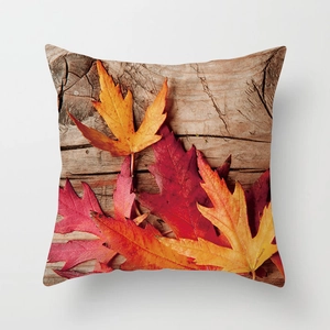 Macro detail of autumn maple leaf print on decorative pillowcase with rustic wood texture