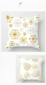 Détails des motifs de feuilles dorées et flocons sur des housses de coussin blanches