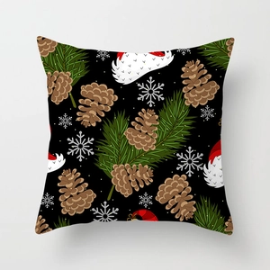 Macro detail of Christmas pillow cover with pine cones, branches, and red hat on black fabric