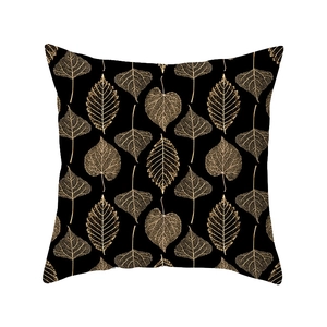 Modern black geometric throw pillow cover with golden leaf vein pattern on white background