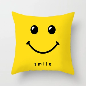 Dettaglio della federa quadrata gialla con icona sorriso nera e scritta smile