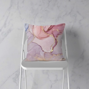 Roze kussensloop met marmertextuur en gouden lijnen op een witte stoel, decor