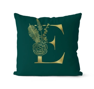 Detailed macro view of green velvet cushion cover with gold letter E and floral pattern