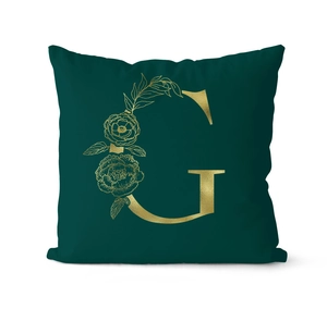 Close-up of luxury dark green velvet pillowcase with gold floral letter G print