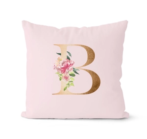 Close-up of letter B printed on pink rose gold cushion cover with floral pattern detail