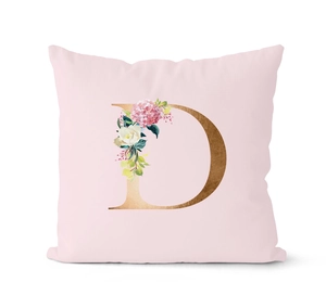 Detail of pink throw pillow case featuring floral letter D with gold texture design