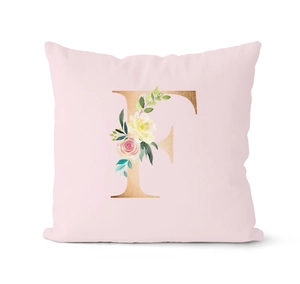 Detail of pink throw pillow case featuring floral gold letter F and watercolor flowers