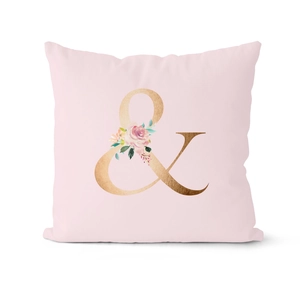 Detail of pink throw pillow case featuring rose gold ampersand and floral pattern