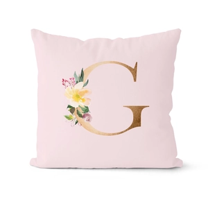 Detailed close-up of pink pillowcase featuring gold letter G and floral watercolor design