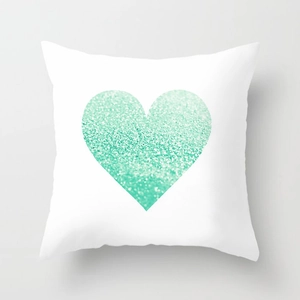 Detail view of square white cushion cover featuring a sparkling mint green glitter heart