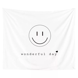 Detail of minimalist white tapestry with black smiley face and wonderful day quote