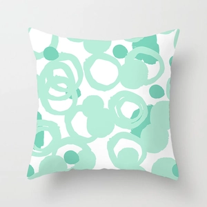 Close-up of mint green geometric circles on white fabric cushion cover with fine texture