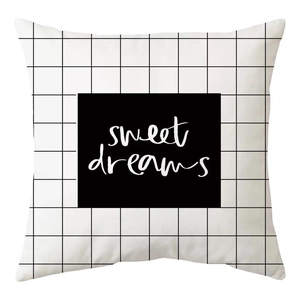 Detail of minimalist black and white grid cushion cover with sweet dreams typography