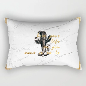 Detail of lumbar pillow case featuring marble texture with cactus print and gold text