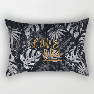 Detail of lumbar pillow case featuring tropical leaves and golden LOVE YOU text design