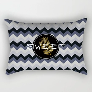 Detail of lumbar pillow case with navy chevron pattern and golden palm leaf print