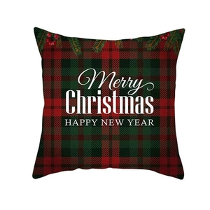 Close-up of red plaid Christmas pillowcase with pine needles and festive holiday greeting