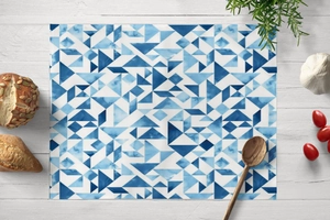 Flat lay of rectangular blue geometric triangle placemat on white wooden table
