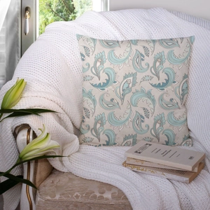 Close-up of paisley pattern pillow cover on a vintage chair with books and white blanket