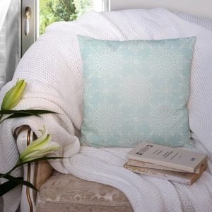 Macro shot of mint green pillow cover with white mandala pattern on a cozy armchair