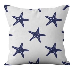 Close-up detail of linen cushion cover showing navy starfish pattern on white fabric