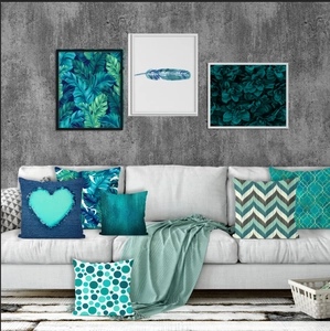 Detail showing six teal geometric and tropical leaf throw pillow covers on a white sofa