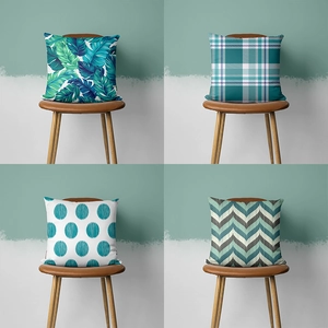 Detail view of teal geometric cushion covers showing tropical leaf and grid patterns