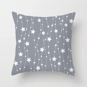 Close-up of peach skin cushion cover with grey geometric star and wave line patterns