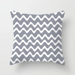 Close-up of peach skin cushion cover featuring grey and white geometric wave patterns