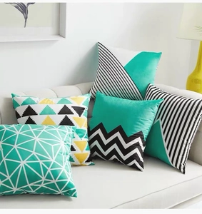 Detail of five geometric pattern cushion covers on white sofa in a cozy modern living room