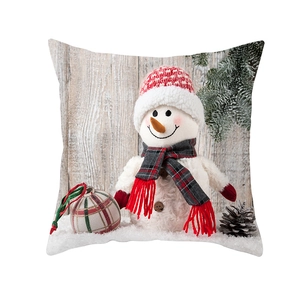 Detail van een kerstkussenhoes met een sneeuwpop, rode gebreide muts en een sjaal