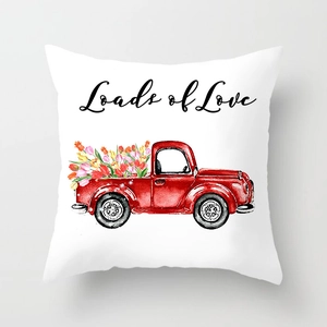 Detail of white throw pillow case featuring watercolor red pickup truck and Loads of Love text