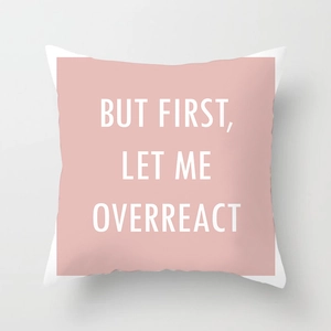 Detail of pink geometric throw pillow cover with white text BUT FIRST LET ME OVERREACT