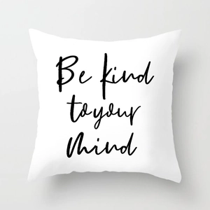 Detail of white square cushion cover with black Be kind to your mind typography print
