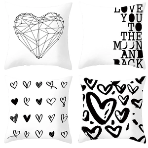 Detail showing four black and white geometric heart patterns and love quotes on cushion covers