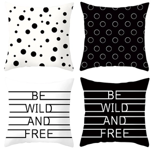 Detailed view of four black and white geometric pillow covers with minimalist slogans