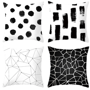 Close-up of four geometric black and white throw pillow covers in a 2x2 grid pattern