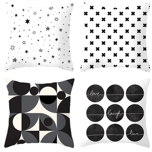 Detail view of four minimalist geometric cushion covers in black, white and grey patterns