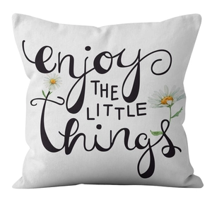 Detail of white daisy cushion cover featuring 'enjoy THE LITTLE things' artistic print