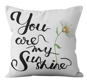 Detail view of white daisy throw pillow cover with You are my sunshine print