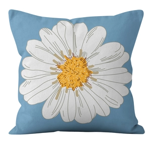 Detailed close-up of blue cushion cover with white daisy print and golden yellow center