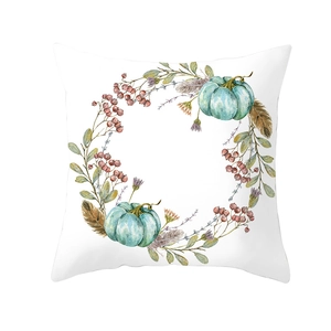 Detail of harvest pumpkin and watercolor wreath design on white square pillowcase