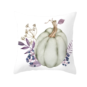 Macro shot of watercolor pumpkin and blue berries print on Thanksgiving cushion cover