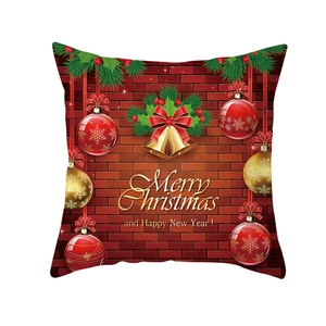 Detail of Christmas pillow cover featuring red bricks, pine branches, and golden bells