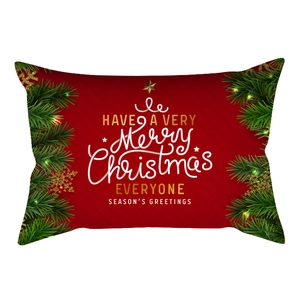 Detail of red Christmas lumbar pillow case with gold snowflakes and festive greenery motifs