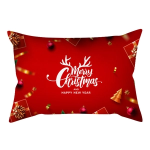 Detail of red Christmas lumbar pillow case with white Merry Christmas lettering and golden bows