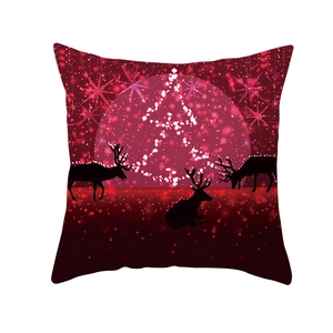 Detail of red Christmas pillowcase with black elk silhouette and festive tree pattern