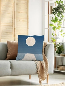 Close-up of modern cushion cover with moon and ocean wave print on a grey fabric sofa