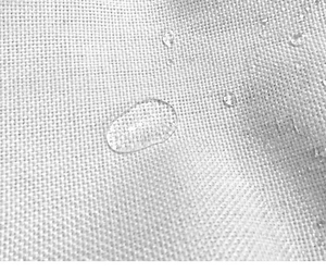 Macro shot of outdoor linen cushion cover showing waterproof texture with water droplets