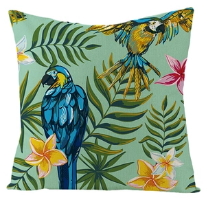 Detail of waterproof linen cushion cover featuring tropical palm leaves and parrots